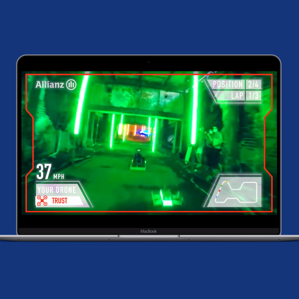 A laptop showing first-person drone race footage in a green-lit warehouse, with speed, position and lap counters overlaid.