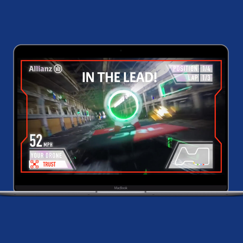 A laptop showing drone race footage with "In the lead!" displayed, the player at 52mph in position one of four.