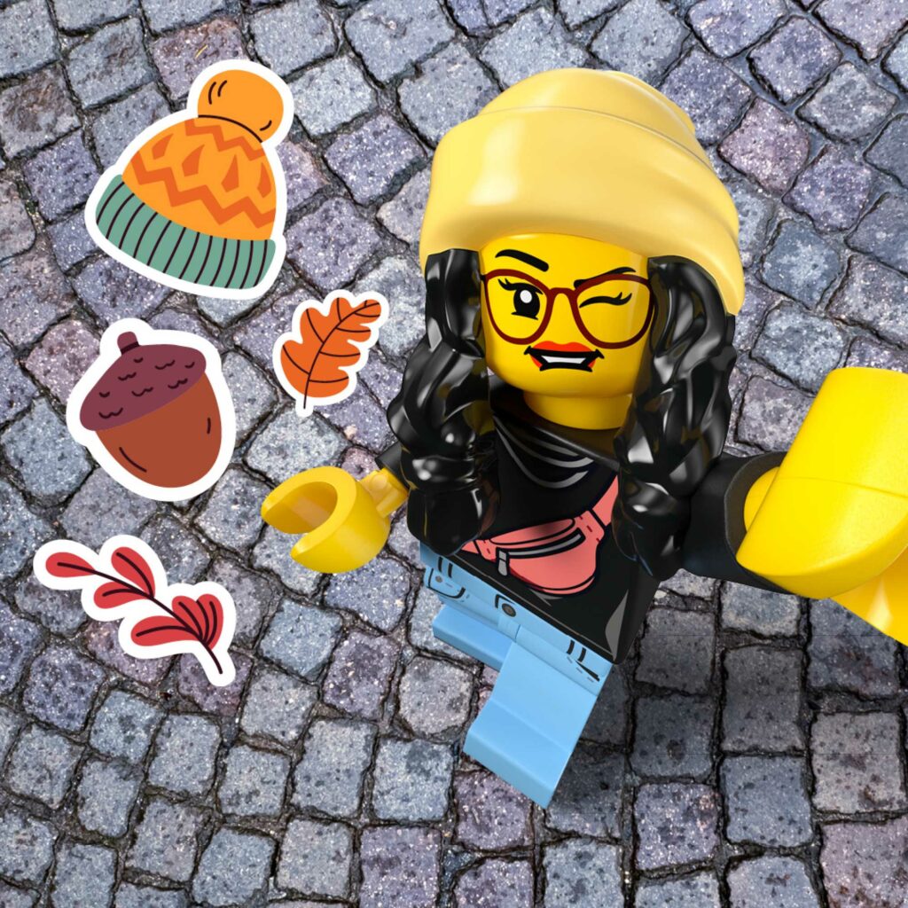 Ming in a yellow beanie taking a selfie on a cobbled street, surrounded by autumn stickers