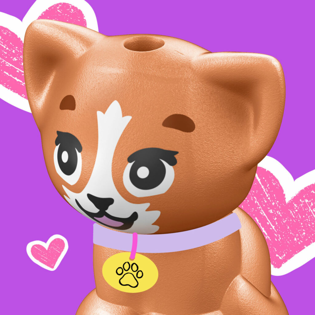 A brown and white LEGO cat wearing a lilac collar with a paw-print tag